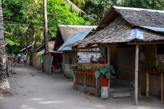 Rustic wooden huts street asian village. Native lifestyle travel photo. Traditional lifestyle of fishermen on sea shore. South Asia indigenous people living. Palm leaf roof on bamboo house