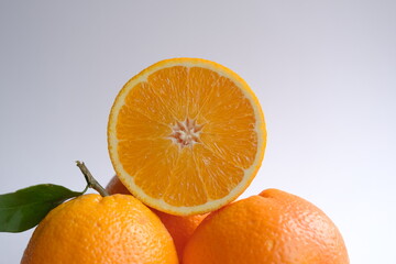 ripe and juicy orange. fresh orange cut in half on a background of oranges with leaves