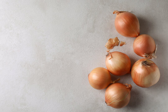 Fresh ripe onion on white textured background