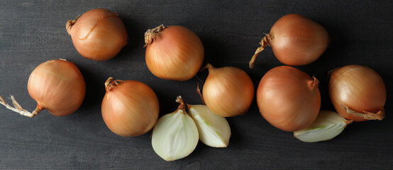 Fresh ripe onion on black wooden table