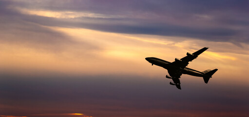 Fototapeta na wymiar Airplane take off on a sunset.