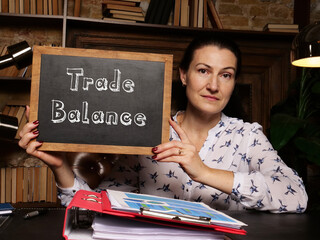 Business concept meaning Trade Balance with phrase on black chalkboard in hand.