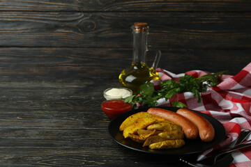 Concept of tasty meal with potato wedges on wooden background