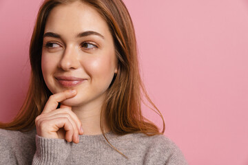 Young ginger thinking woman smiling and looking aside