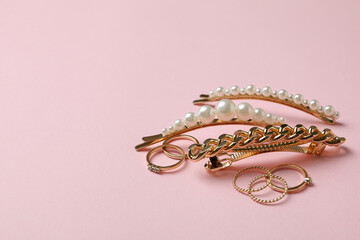 Hair clips and rings on pink background