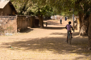 Fototapeta premium A girl riding a bicycle in rural The Gambia