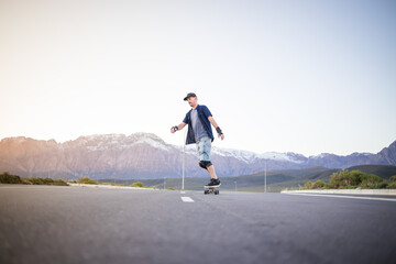 Skateboarder skateboarding on an open road doing freestyle tricks