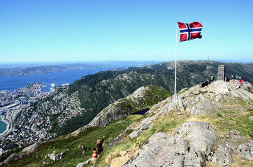 Naklejka premium Norway, Bergen: Scenic aerial view of the cityscape with the Norwegian flag on the foreground