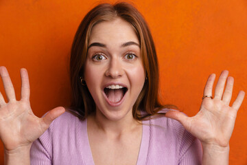 Young ginger excited woman screaming while showing her palms at camera