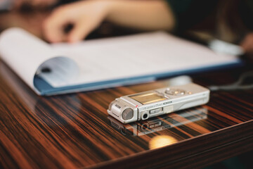 Shallow depth of field (selective focus) image with an audio recorder of a woman journalist during...
