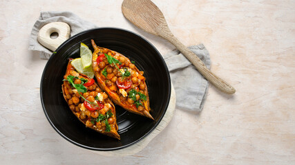 Stuffed sweet potato with spiced chickpea, dressing and herbs.