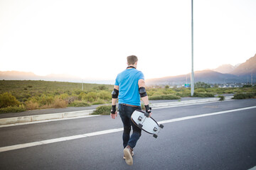 Skateboarder skateboarding on an open road doing freestyle tricks