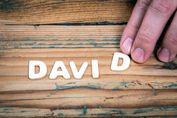 DAVID. Name of men and boys. Birthday concept. White letters of the alphabet on a wooden background