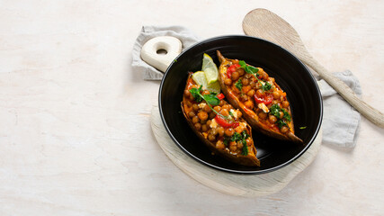 Stuffed sweet potato with spiced chickpea, dressing and herbs.