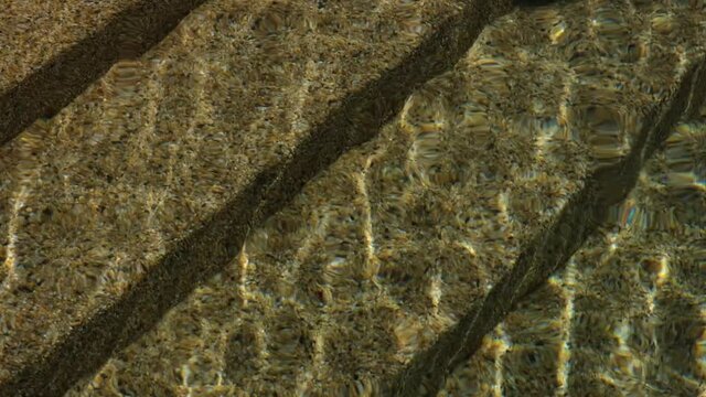 Swimming Pool Steps Bathed In Golden Sunshine With Rippling Water And Dancing Light