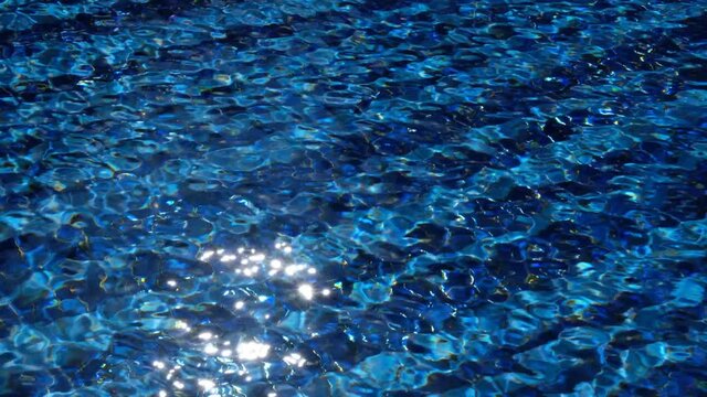 4k Footage Of Sunlight Dancing Across Blue Tiled Swimming Pool