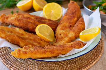 A plate with breaded fish fillets