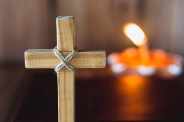 The cross has a candle that illuminates. Christian religious concept, the crucifixion of faith and...