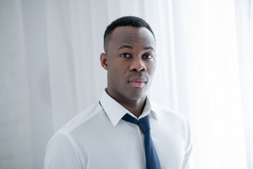 A young african american man wearing a tie and looking fashionable