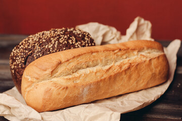 flour products rye bread on packaging and wooden table knife red background