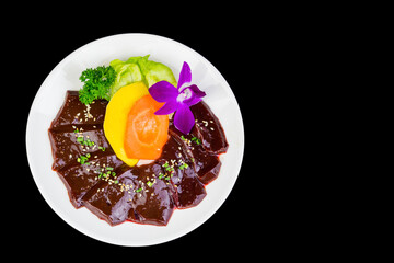 Fresh beef liver cut into a plate isolated on back background