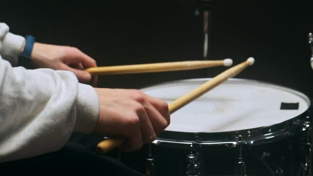 The drummer plays with sticks on a snare drum, home lesson training.