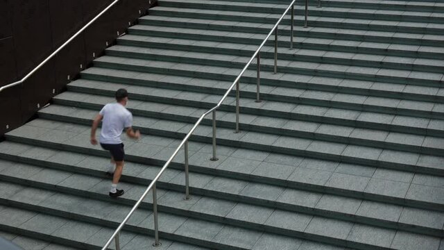 4k Footage Of A Caucasian Man Running Up An Empty Urban Concrete Staircase In A City Park.