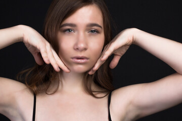 Young brown-haired woman, studio photo on black background