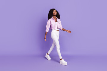 Full size photo of young beautiful smiling positive afro girl go walk looking copyspace isolated on violet color background