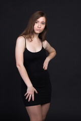 Naklejka premium Young brown-haired woman, studio photo on black background