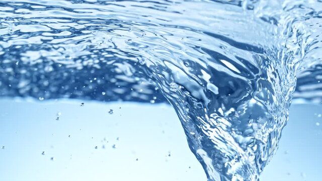 Super Slow Motion Shot of Water Whirl on Light Blue Gradient Background at 1000fps.