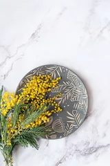 Türaufkleber mimosa flowers and plate on abstract grey marble background. spring seasonal festive composition. flat lay. copy space © Ju_see