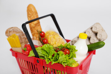 close up of shopping basket full of products over white
