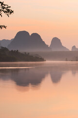 A tranquil summer lake at sunrise.