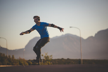 Obraz na płótnie Canvas Skateboarder skateboarding on an open road doing freestyle tricks
