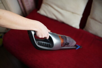 Fototapeta premium Cleaning with a portable cordless vacuum cleaner. Soft selective focus