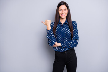 Photo of charming cute young lady wear blue shirt hands folded pointing thumb up empty space...