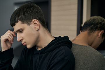 Staged photo illustrates problems and conflicts in gay couple relationships. Young upset and...