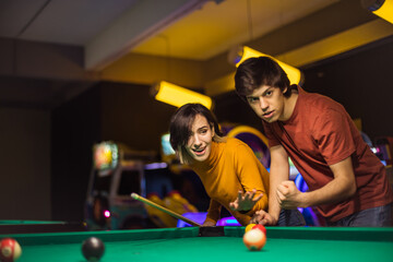 Couple playing billiards together.