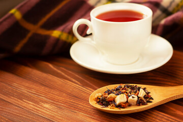 dried tea leaves and brewed tea in a white mug