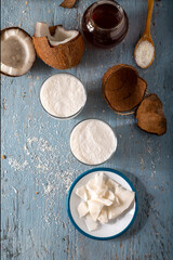 Glass of Coconut Smoothies with Coconut. Coconut smoothie vith slices of fresh coconut and flakes in spoon on wooden background. Top view.