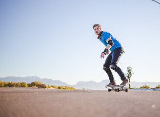 Skateboarder skateboarding on an open road doing freestyle tricks