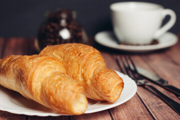 croissants in a plate a cup with a drink a meal dessert 