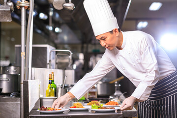 Asian Male chef presenting the dish in the kitchen. Food and restaurant concept .Selective focus.