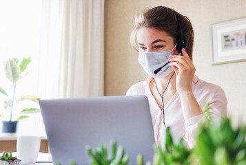 A telephone sales agent wears a headset during the coronavirus pandemic - Hot line operator girl...