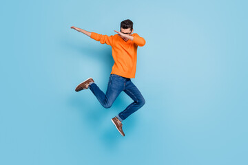 Fototapeta na wymiar Full length photo of young excited man jump up dab hip-hop dance active energetic isolated over blue color background