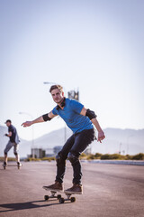Fototapeta premium Skateboarder skateboarding on an open road doing freestyle tricks