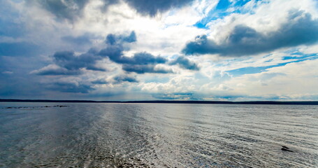 River banks against blue sky with white clouds in summer