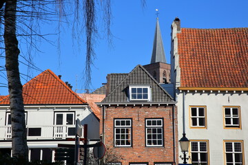 Historic house facades along Krommestraat street in Amersfoort, Utrecht, Netherlands, with the clock tower of Sint Joriskerk (St George's church) in the background