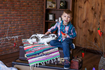 boy in a good mood plays with an Easter bunny, joy on the baby's face